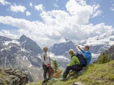 Hikers relax on grassy mountain slope in the morning