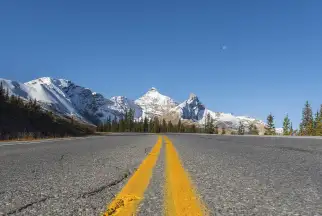 a road stretches towards a snowy mountain peak in British Columbia, Canada