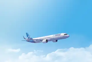 An Air Transat planes flies through the sky