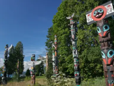 Indigenous totem poles stand in a field