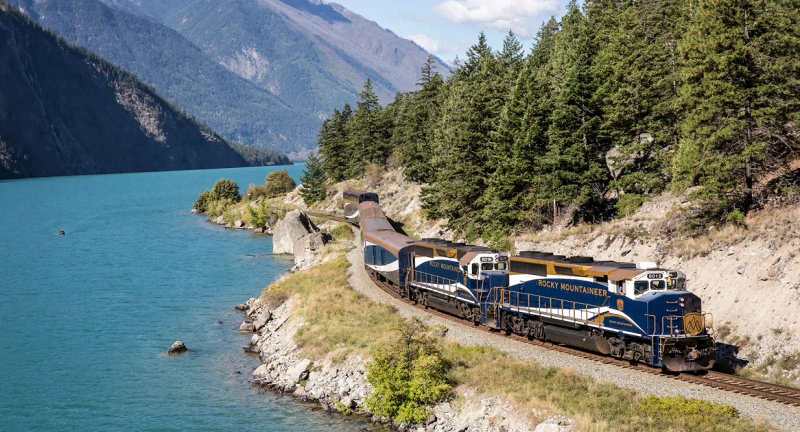 Rocky Mountaineer train curves round a crystal blue lake