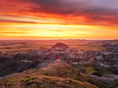 a woman looks out at a setting sun over the Saskatchewan prairies